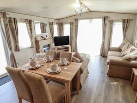 A living room with a sofa, dining table and television at Tattershall Lakes Country Park - Holiday Accommodation 16408, Tattershall