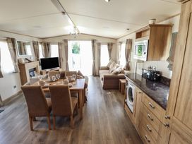 A living room with a TV, sofa, and dining table at Tattershall Lakes Country Park - Holiday Accommodation 16408 in Tattershall