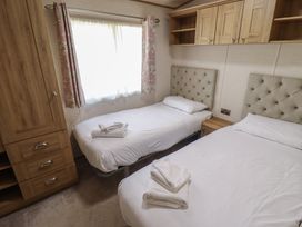 A bedroom with twin beds and a cabinet at Tattershall Lakes Country Park - Holiday Accommodation 16408 Tattershall
