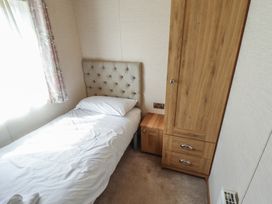 A bedroom with a bed and wooden furniture at Tattershall Lakes Country Park - Holiday Accommodation 16408 in Tattershall