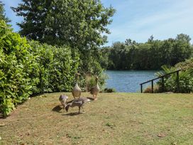 A grassy area with ducks near a water body at Tattershall Lakes Country Park - Holiday Accommodation 16408 in Tattershall