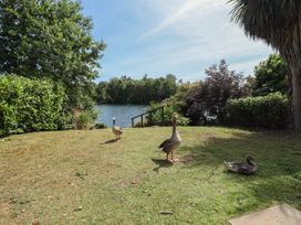 A backyard with a grass area, a lake, and ducks at Tattershall Lakes Country Park - Holiday Accommodation 16408 Tattershall