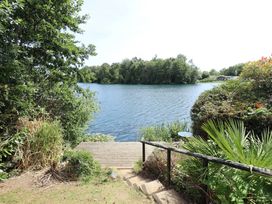 A dock leading to a water body surrounded by trees at Tattershall Lakes Country Park - Holiday Accommodation 16408, Tattershall