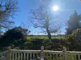 A view of trees and a field with a table at Kelling Heath Holiday Park - Holiday Accommodation 16498 Holt