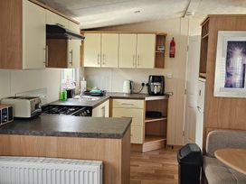 A kitchen with appliances and cabinets at Hayling Island Holiday Park - Meadow Bay Villages - Holiday Accommodation 16626 Hayling Island