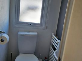 A bathroom with a toilet, sink, window and towel radiator at Hayling Island Holiday Park - Meadow Bay Villages - Holiday Accommodation 16626 Hayling Island