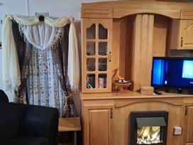 A living room with a cabinet and television at The Chase - Holiday Accommodation 1675 in Ingoldmells