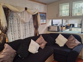 A living room with a sofa and cabinet at The Chase - Holiday Accommodation 1675 in Ingoldmells