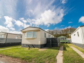 A caravan with steps and lawn at WigBay Holiday Park - Holiday Accommodation 16774 Stranraer