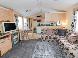 A living room with a sofa and dining area at WigBay Holiday Park - Holiday Accommodation 16774, Stranraer