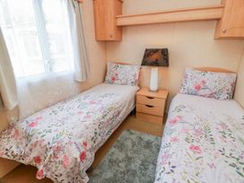 A bedroom with two beds and a lamp at WigBay Holiday Park - Holiday Accommodation 16774 Stranraer