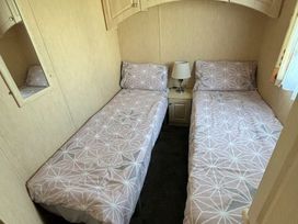 a bedroom with two single beds and a lamp in Coral Beach - Holiday Accommodation 16858 Inglemells