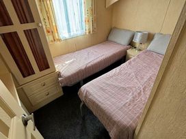 a bedroom with two single beds and a window at Coral Beach - Holiday Accommodation 16858 in Ingoldmells