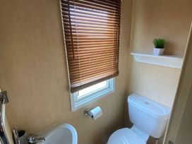 a small bathroom with a toilet and a sink at Coral Beach - Holiday Accommodation 16858 in Ingoldmells