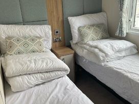 a bedroom with two single beds and patterned cushions at Quay West Holiday Park - Holiday Accommodation 16905, New Quay
