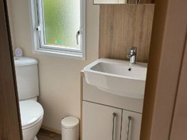 a bathroom with a toilet, sink, and window at Quay West Holiday Park - Holiday Accommodation 16905, New Quay