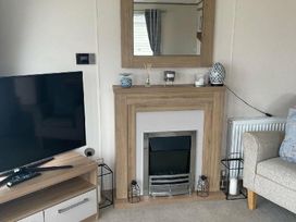 a living room with a fireplace and a mirror on the wall at Quay West Holiday Park - Holiday Accommodation 16905, New Quay
