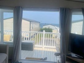 a view from a room showcasing a balcony and nearby static caravans at Quay West Holiday Park - Holiday Accommodation 16905, New Quay