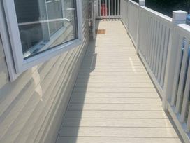 a walkway with railings beside a building at Quay West Holiday Park - Holiday Accommodation 16905 in New Quay