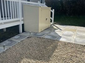 a paved area with a storage shed and gravel at Quay West Holiday Park - Holiday Accommodation 16905 in New Quay