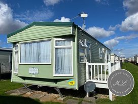 a green caravan with a porch and windows at Seaview Caravan Park - Holiday Accommodation 16924 in Ingoldmells