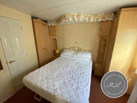 a bedroom with a bed and wooden furniture at Seaview Caravan Park - Holiday Accommodation 16924 in Ingoldmells