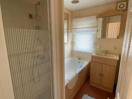 a bathroom with a shower, bathtub, and sink at Seaview Caravan Park - Holiday Accommodation 16924 in Ingoldmells