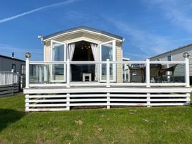 A deck with chairs and a door at Chesil Beach Holiday Park - Holiday Accommodation 16933, Weymouth