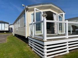 A caravan with a deck and a railing at Chesil Beach Holiday Park - Holiday Accommodation 16933, Weymouth