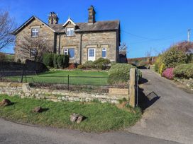 An exterior view of a house with a garden at 2 Lupton Hall Cottages in Carnforth