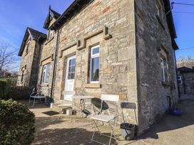 An outdoor area with chairs and a table at 2 Lupton Hall Cottages in Carnforth
