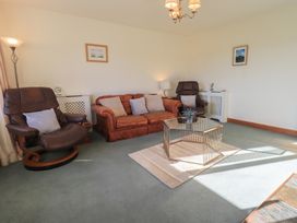 A living room with a sofa and armchairs at 2 Lupton Hall Cottages Carnforth