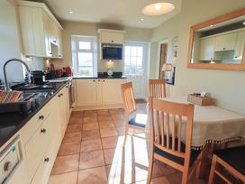 A kitchen with dining table and appliances at 2 Lupton Hall Cottages in Carnforth