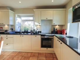 A kitchen with a sink and stove at 2 Lupton Hall Cottages in Carnforth