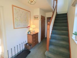A hallway with a staircase and a chest of drawers at 2 Lupton Hall Cottages in Carnforth