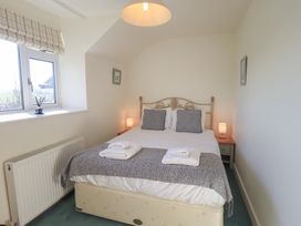 A bedroom with a bed and bedside table at 2 Lupton Hall Cottages Carnforth