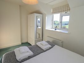 A bedroom with a bed and wardrobe at 2 Lupton Hall Cottages in Carnforth