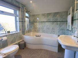 A bathroom with a bathtub, toilet, and sink at 2 Lupton Hall Cottages Carnforth