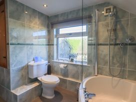 A bathroom with a shower and bathtub at 2 Lupton Hall Cottages, Carnforth