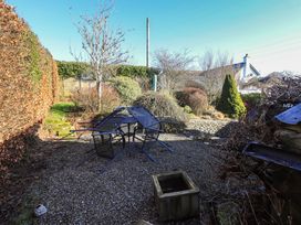 A garden with chairs and a table at 2 Lupton Hall Cottages, Carnforth
