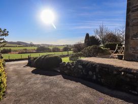 A view of a field and chair under sunlight at 2 Lupton Hall Cottages in Carnforth
