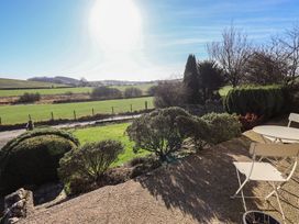 A garden with a view of fields and seating at 2 Lupton Hall Cottages in Carnforth