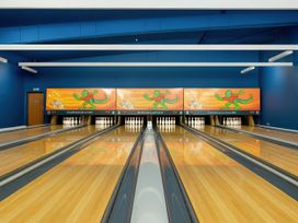 A bowling alley with lanes and a colorful mural at Freshwater Beach Holiday Park - Holiday Accommodation 17116 Burton Bradstock near Bridport