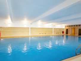 An indoor swimming pool with tile walls and changing room at Freshwater Beach Holiday Park - Holiday Accommodation 17116 Burton Bradstock near Bridport