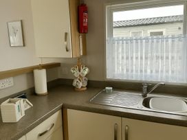 A kitchen with a sink and cup rack at Freshwater Beach Holiday Park - Holiday Accommodation 17116 in Burton Bradstock near Bridport