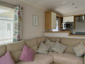 A living room with a sofa and kitchen unit at Freshwater Beach Holiday Park - Holiday Accommodation 17116 in Burton Bradstock near Bridport