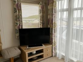 A living room with a television on a stand at Freshwater Beach Holiday Park - Holiday Accommodation 17116 Burton Bradstock near Bridport