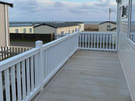 a balcony with a white railing overlooking the sea at Freshwater Beach Holiday Park - Holiday Accommodation 17116 Burton Bradstock near Bridport