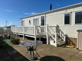 An outdoor area with a caravan and a table at Freshwater Beach Holiday Park - Holiday Accommodation 17116 Burton Bradstock near Bridport