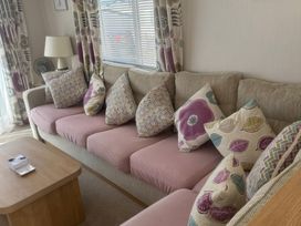 A living room with a sofa and cushions at Freshwater Beach Holiday Park - Holiday Accommodation 17116, Burton Bradstock near Bridport